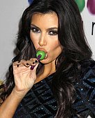 Kim Kardashian wearing a body-hugging dress while sucking a lollipop in these pics